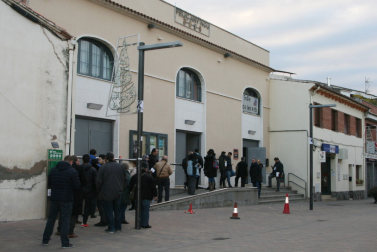Votants esperant a entrar al col·legi electoral de la Sala Polivalent instants abans d'obrir portes.